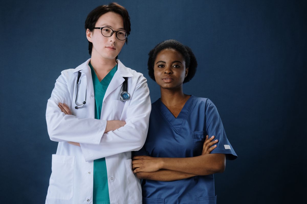 A home health professional in blue scrubs smiling — the NYC caregiving workforce.